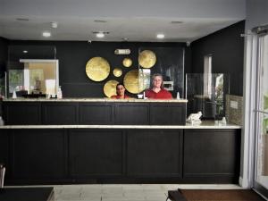 a man and a woman standing behind a bar at Fairway Inn Florida City Homestead Everglades in Florida City