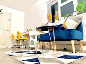 a living room with a blue couch and yellow chairs at Kunda House Sparkbrook in Birmingham