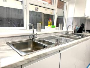 a kitchen with a stainless steel sink and a window at Kunda House Sparkbrook in Birmingham