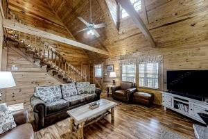 a living room with a couch and a tv in a cabin at Mountain Lion's Tales in Gatlinburg