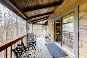 a wooden porch with benches on a deck at Mountain Lion's Tales in Gatlinburg