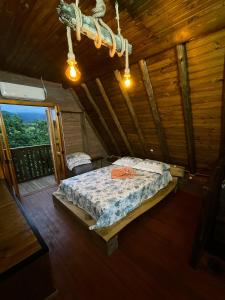 1 dormitorio con 1 cama en una cabaña de madera en HOSPEDAGEM LA NO SITIO, en Praia Grande
