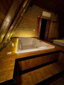 bañera en una habitación con suelo de madera en HOSPEDAGEM LA NO SITIO, en Praia Grande