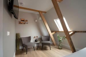 a living room with two chairs and a tv at The Lake Inn in Nieuwkoop