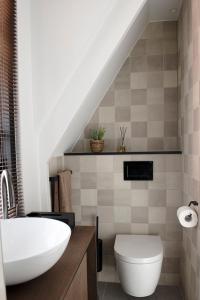 a bathroom with a white sink and a toilet at The Lake Inn in Nieuwkoop