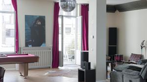 ein Wohnzimmer mit roten Vorhängen und einem Tisch in der Unterkunft DUPLEX STYLE NEW-YORKAIS ! in Brüssel