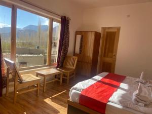 a bedroom with a bed and a large window at Nima's Villa in Leh