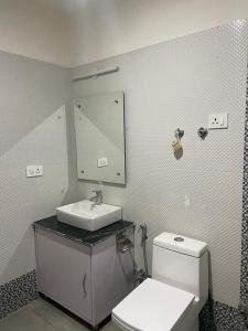 a bathroom with a white toilet and a sink at Nima's Villa in Leh +15 photos
