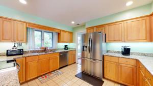 a kitchen with wooden cabinets and a stainless steel refrigerator at 40 Mooring Buoy in Hilton Head Island