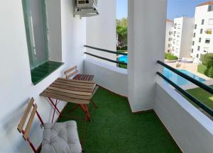 un balcón con 2 sillas y una mesa y un balcón con piscina en Apartamento con encanto en playa las Redes, en El Puerto de Santa María