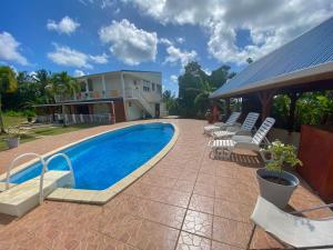 a swimming pool in front of a house at VILLA TIBOU in Petit-Bourg