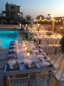 a long table with candles and wine glasses next to a pool at Niovi Boutique Apartments in Afitos