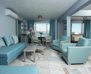 sala de estar con muebles azules y mesa en kon&kona hrakleitsa, en Nea Iraklitsa