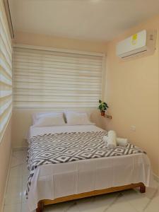 a large bed in a bedroom with a window at Buritaca House in Buritaca