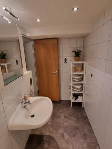 a bathroom with a sink and a wooden door at Ferienwohnung Alina in Rust +9 photos
