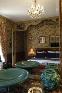 a bedroom with a bed and vases on a table at Chateau de Vaux in Yvré-lʼÉvêque