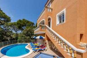 une villa avec une piscine à côté d'un bâtiment dans l'établissement Villa Carmen Galdana by Villa Plus, à Cala Galdana