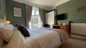 Dormitorio con cama, escritorio y TV en Southcliffe B&B en Lynton