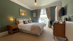 
a bedroom with a large bed and a large window at Southcliffe B&B in Lynton
