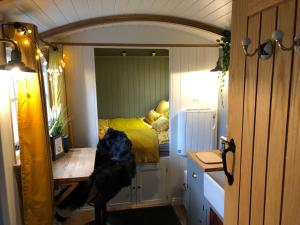um pequeno quarto com uma cama num espelho em Miners Hut em St Austell