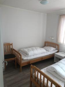 a bedroom with two twin beds and a chair at Hede, stuga in Hede