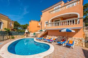 a villa with a swimming pool in front of a house at Villa Dolores by Villa Plus in Cala Galdana