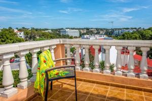 a chair on a balcony with a view of a city at Villa Dolores by Villa Plus in Cala Galdana