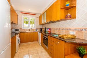 a kitchen with wooden cabinets and a dishwasher at Villa Dolores by Villa Plus in Cala Galdana