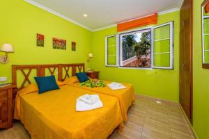 two beds in a room with green walls at Villa Dolores by Villa Plus in Cala Galdana