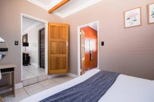 a bedroom with a bed and a wooden door at Beautiful and Modern apartment close to Menlyn in Pretoria