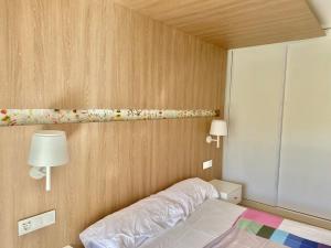een slaapkamer met een bed en twee lampen aan een muur bij apartament de luxe con piscina in Salou +72 foto's