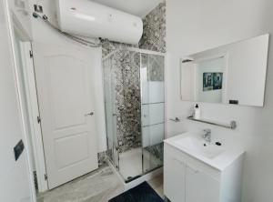 baño blanco con ducha y lavamanos en Sunlight Málaga Centro en Málaga