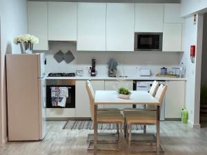 a kitchen with a table and chairs and a refrigerator at MIRASOL 10 in Figueira da Foz