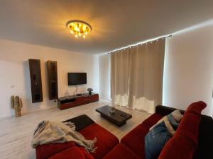 a living room with a red couch and a tv at MIRASOL 10 in Figueira da Foz