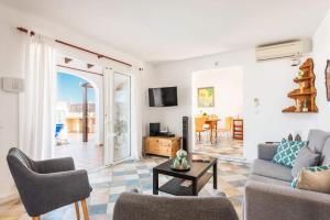 a living room with a couch and chairs and a table at Villa Marina Way by Villa Plus in Sant Lluis