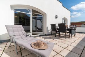 a patio with chairs and a table with a hat on it at Strandhaus Belvedere in Binz +47 photos
