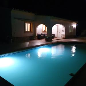a swimming pool lit up at night at Belle villa à Oliva proche de la mer et de la montagne in Oliva