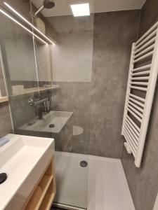 a bathroom with a shower and a sink and a tub at Allgäuer Heimat in Rettenberg