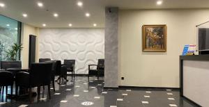 a dining room with black chairs and a wall at Batesta Hotel in Tbilisi City