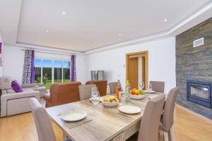 uma sala de jantar com uma mesa e uma lareira em Villa Quinta dos Abacates by Villa Plus nos Olhos de Água
