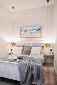 a bedroom with a large white bed with two lamps at Cherry House Apartments in Bydgoszcz