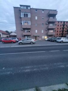 a parking lot with cars parked in front of a building at Raven2 in Kolonija