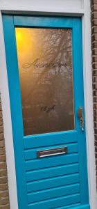 Una puerta azul con un cartel. en Ferienhaus Abenteuer, en Egmond aan Zee