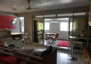 a room with a living room with a table and chairs at Un pied-à-terre au centre de Papeete in Papeete