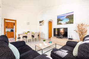 ein Wohnzimmer mit einem Sofa und einem TV in der Unterkunft Villa Rotxa by Villa Plus in Cala'n Bosch