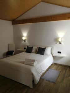 1 dormitorio con 1 cama blanca grande y 2 almohadas en Casa Xavier, en Ponta Delgada