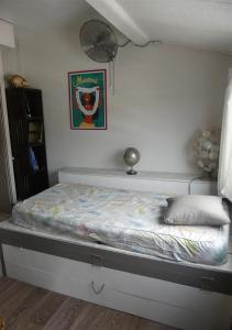 Ce lit se trouve dans une chambre dotée d'un mur blanc. dans l'établissement Un pied-à-terre au centre de Papeete, à Papeete 7 autres photos