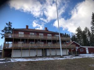 a large red house with a large deck at Järvsö Kramstatjärnsvägen 10E in Järvsö