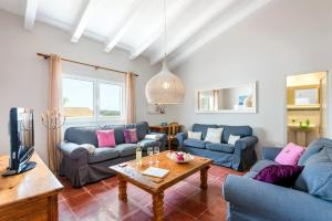 a living room with blue couches and a table at Villa Son Muscart by Villa Plus in Es Mercadal