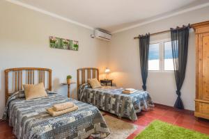a bedroom with two beds and a window at Villa Son Muscart by Villa Plus in Es Mercadal +26 photos